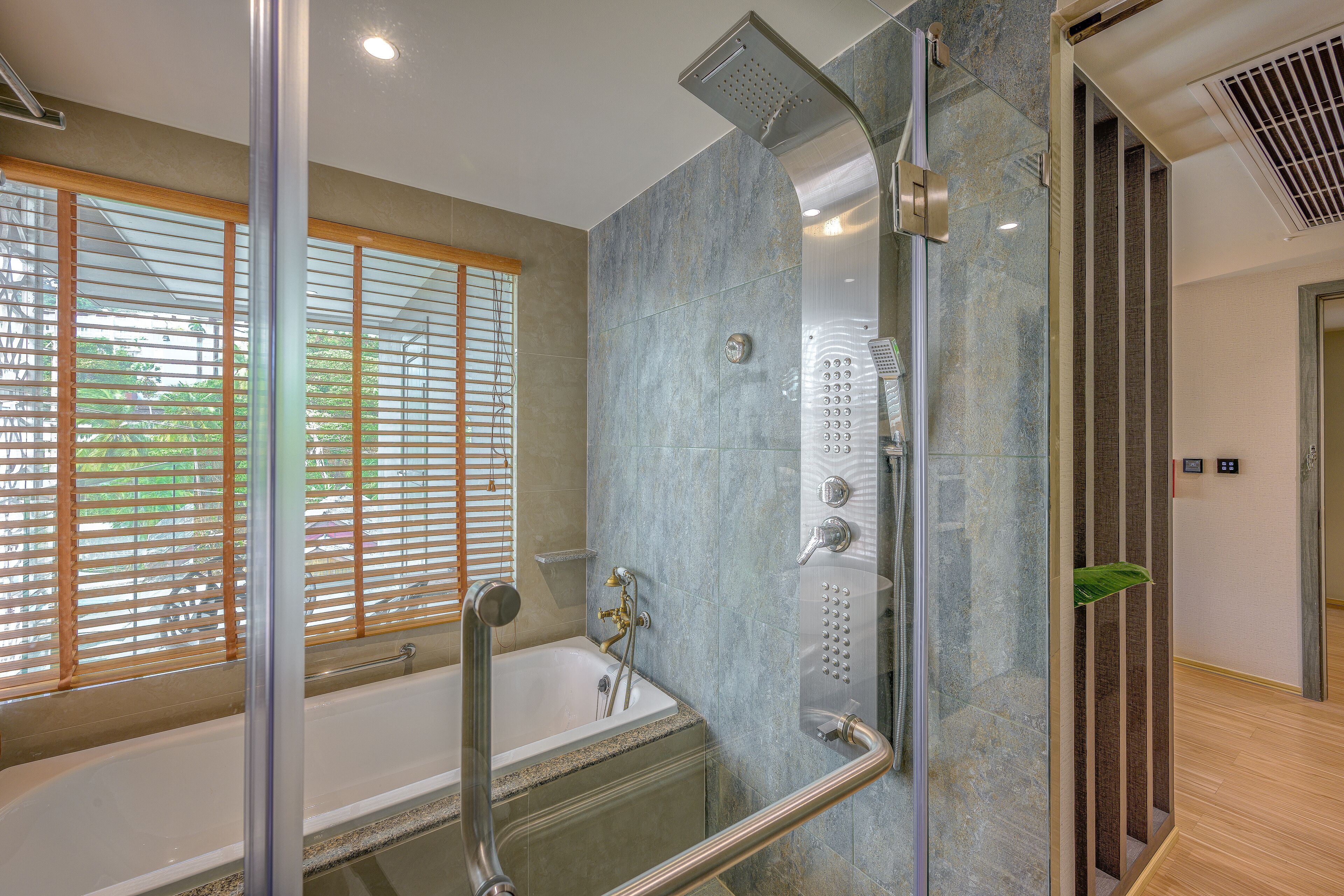 A modern bathroom with a bathtub, shower, and glass-enclosed shower area.