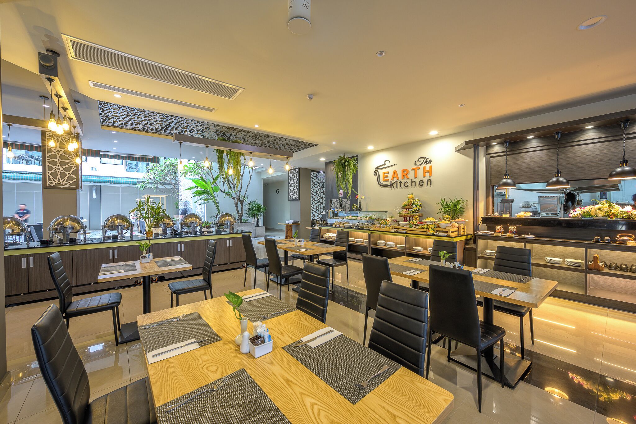 Un restaurante moderno con una barra central, varias mesas de comedor y sillas negras.