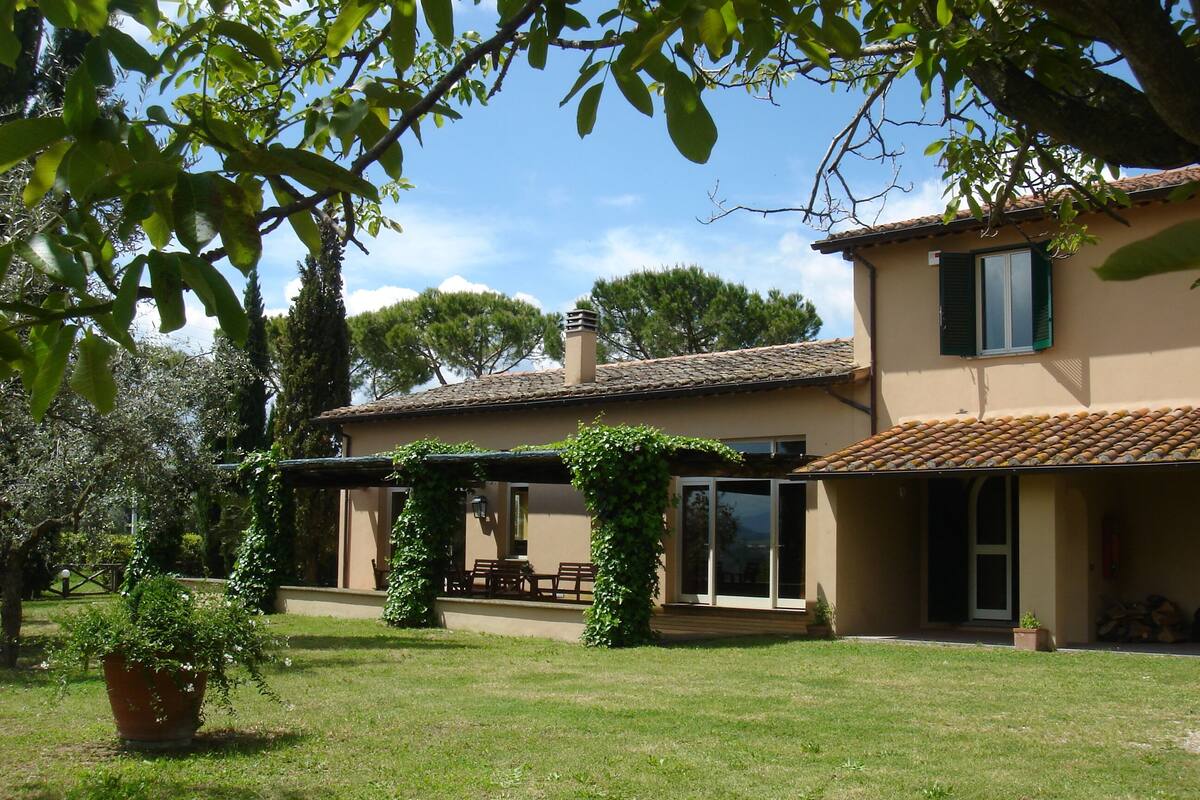 A house with a covered patio, a lawn, and a garden.