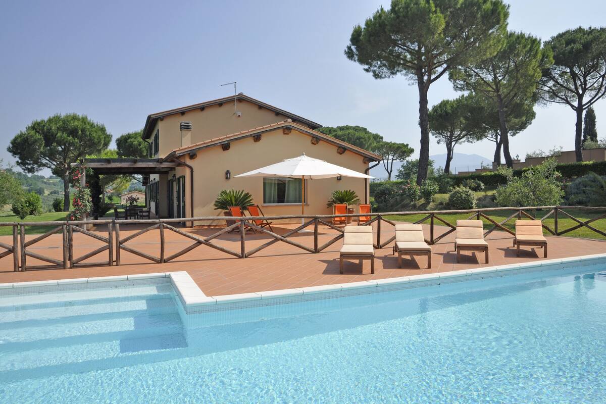 A swimming pool area with lounge chairs and a pergola.