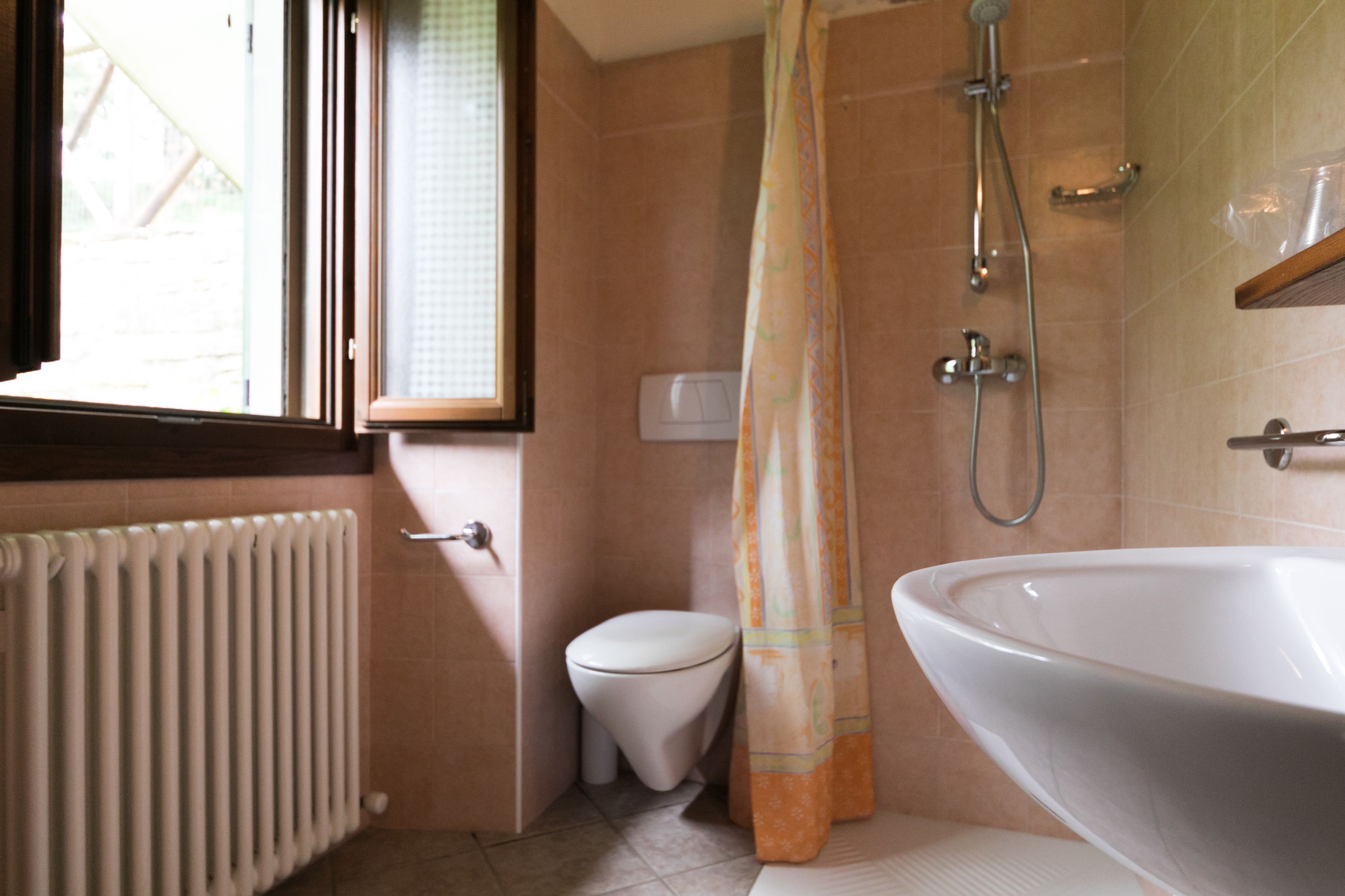 Un baño con inodoro, ducha y un lavamanos grande.