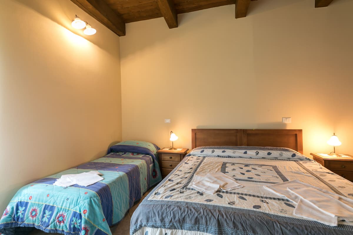 Une chambre avec deux lits, des têtes de lit en bois et des lampes de chevet.