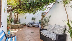 A cozy patio area with a wicker sofa, a blue bench, and a small table. - 14 Leoni (Salerno)