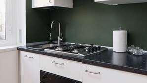 Appartement, 2 slaapkamers, balkon, uitzicht op binnenplaats | Privékitchenette | Een koelkast, een kookplaat, kookgerei, borden en bestek