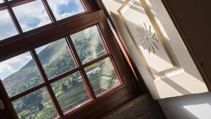 A room with a large window offering a view of a mountainous landscape. - Casa do Monte (Baiao)