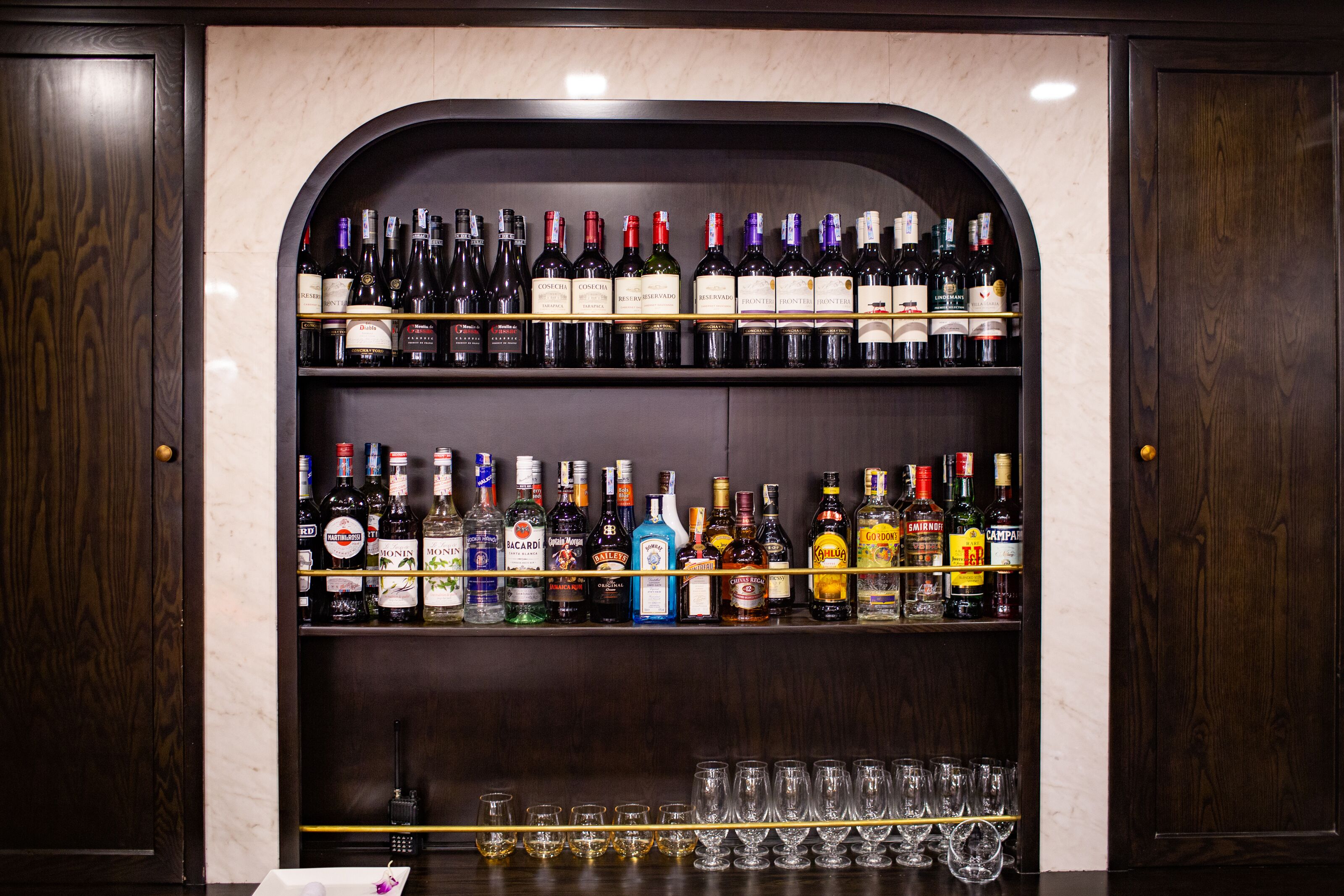Een bar met talloze flessen drank en glazen.