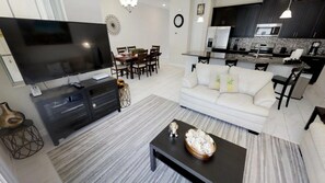 Relax in a spacious living area with a flat-screen TV, comfortable sofa, and dining space.