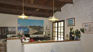 A reception area with a beach view, a desk with a computer, keys on the wall, and a logo on the wall. - Village Camping  de l'Ostriconi (Palasca)