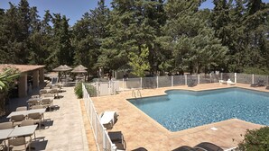 A swimming pool with a tiled deck, surrounded by white fencing, and shaded by trees. - Village Camping  de l'Ostriconi (Palasca)