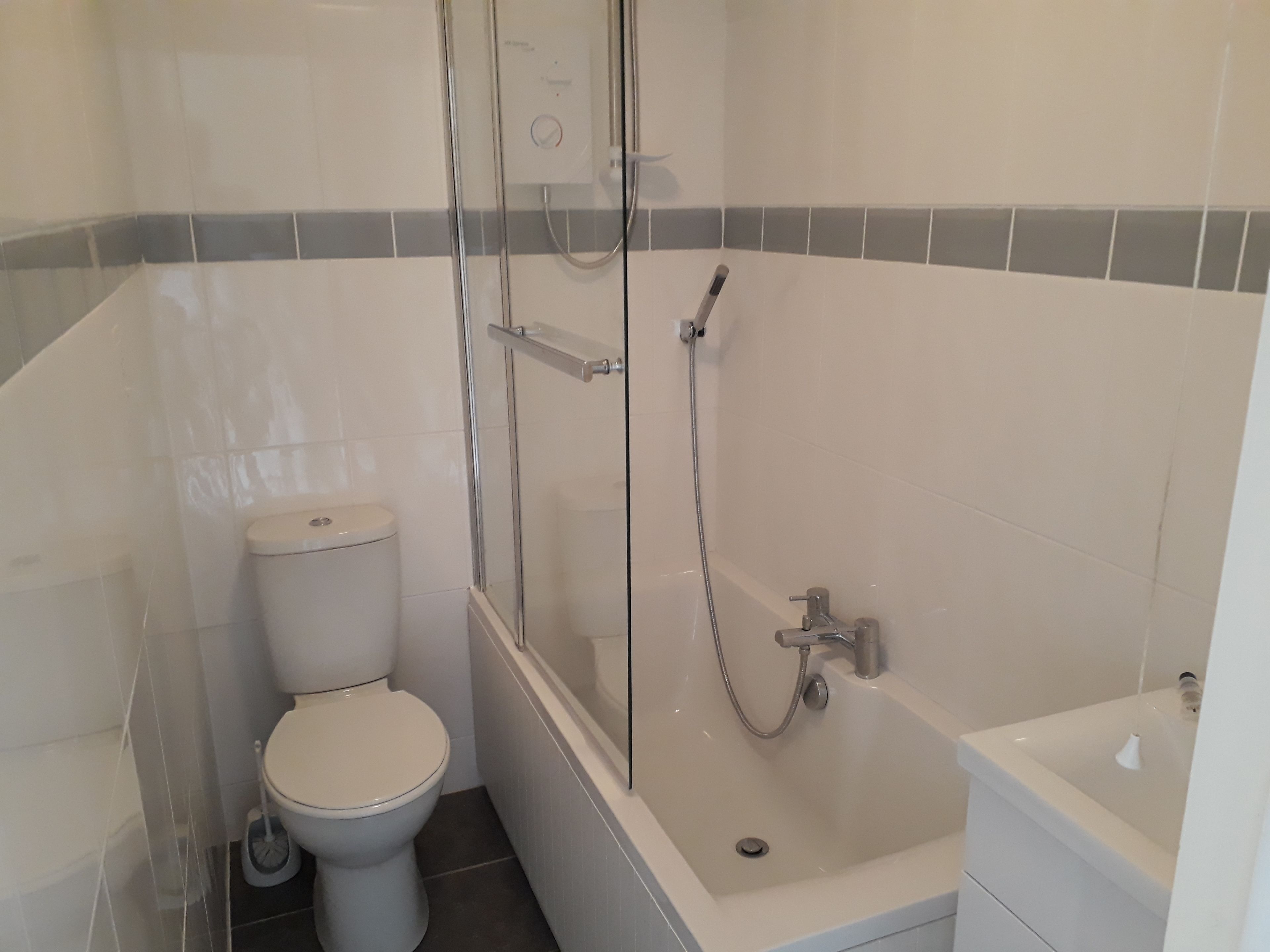 A bathroom with a toilet, shower, and bathtub.