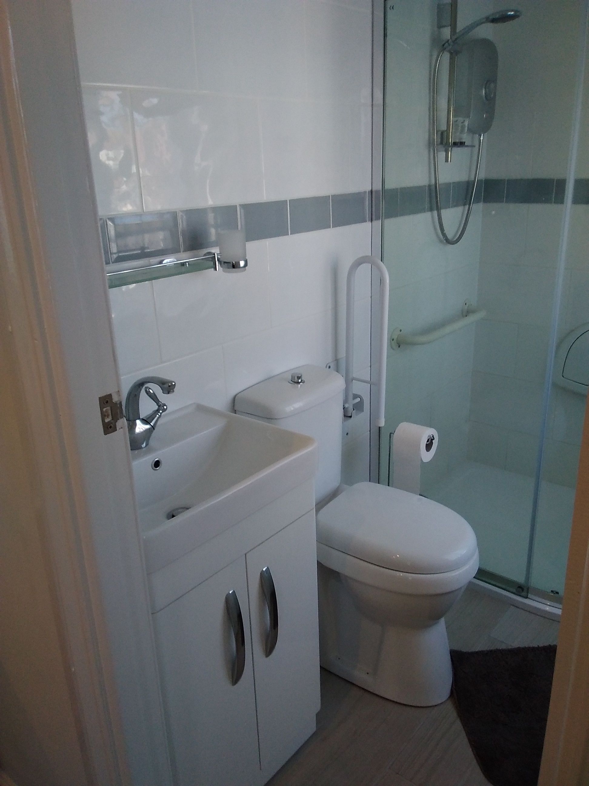 A modern bathroom with a toilet, sink, and glass-enclosed shower.