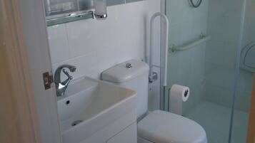 A modern bathroom with a toilet, sink, and glass-enclosed shower.