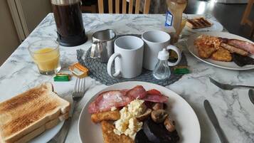 Una mesa de desayuno con tostadas, huevos, champiñones y tocino.