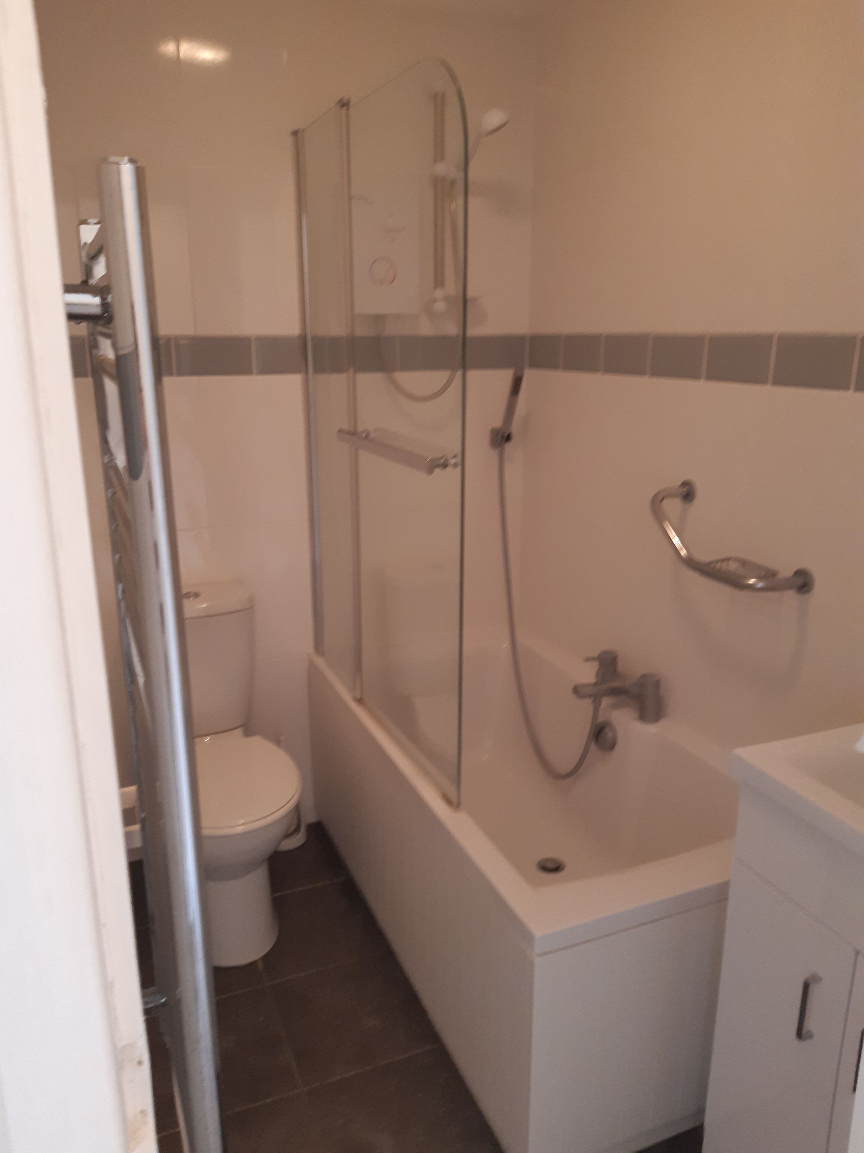 Une salle de bain avec une douche à parois de verre, des toilettes et une baignoire.