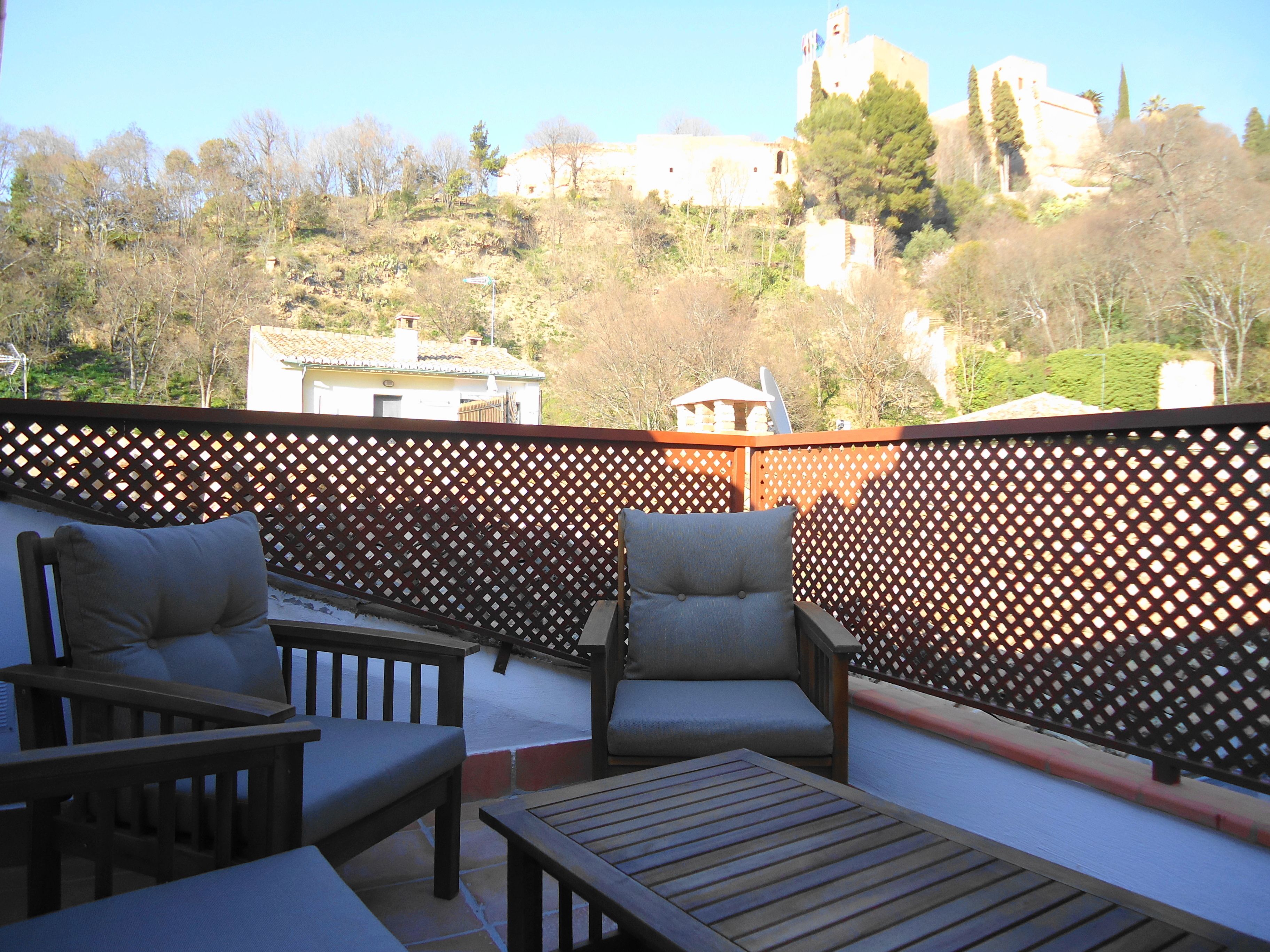 A terrace with wooden furniture and a lattice fence.