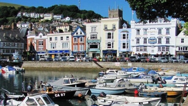 A marina with various boats docked, a Royal Hotel building, and a hillside with houses. - Dartmouth Chalet Holidays (Dartmouth)