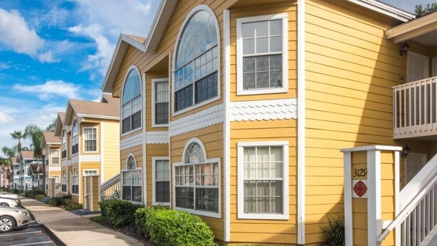 A row of yellow townhouses with white trim, numbered 3129, featuring large windows and a small balcony. - Ip60497 - Island Club West - 3 Bed 2 Baths Condo (Kissimmee)