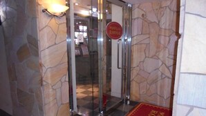 A hotel entrance with a glass door, a red sign, and a red carpet. - HOTEL MOULIN ROUGE - Adults Only (Ibaraki)