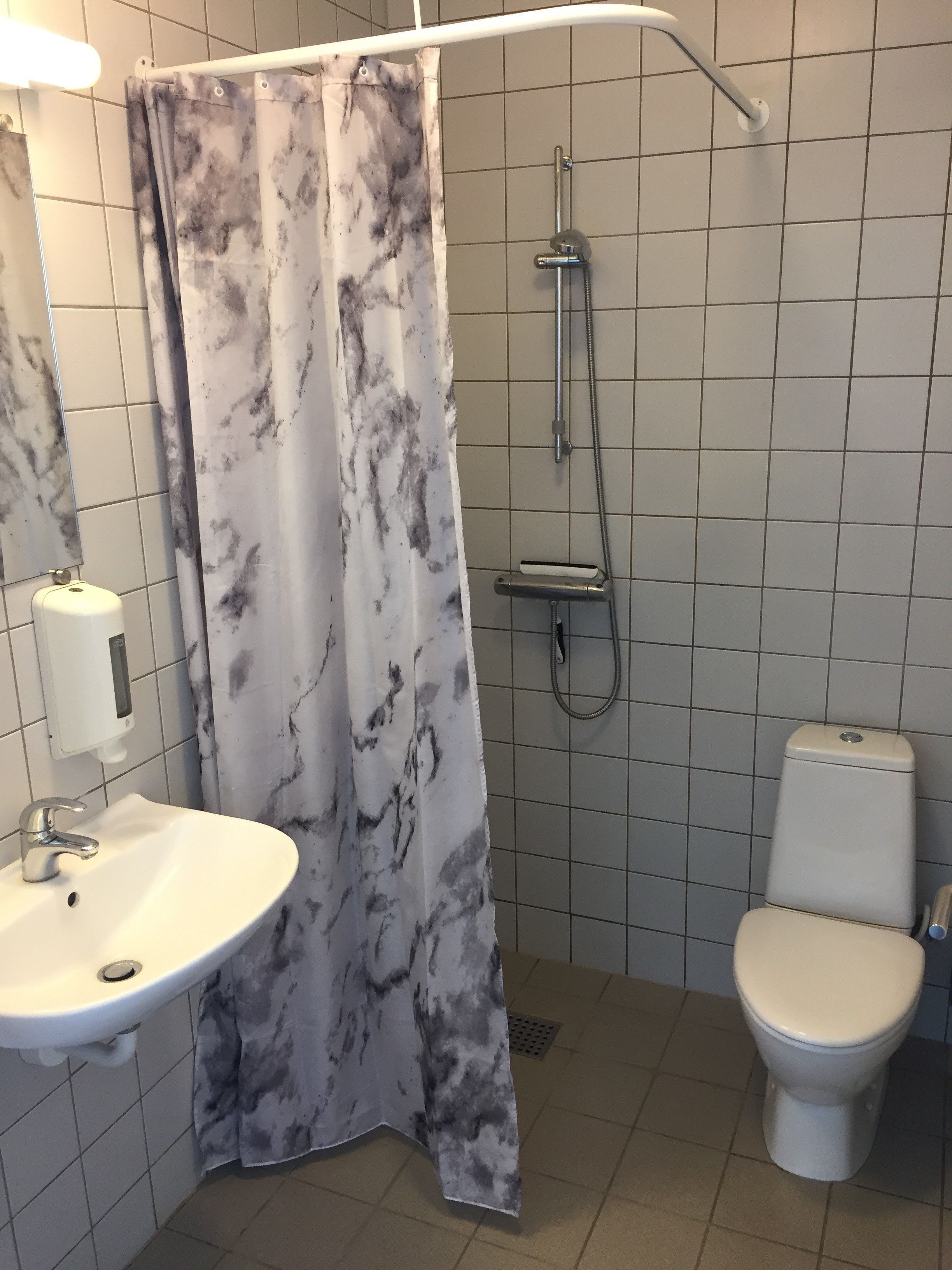 A bathroom with a white sink, toilet, and shower.