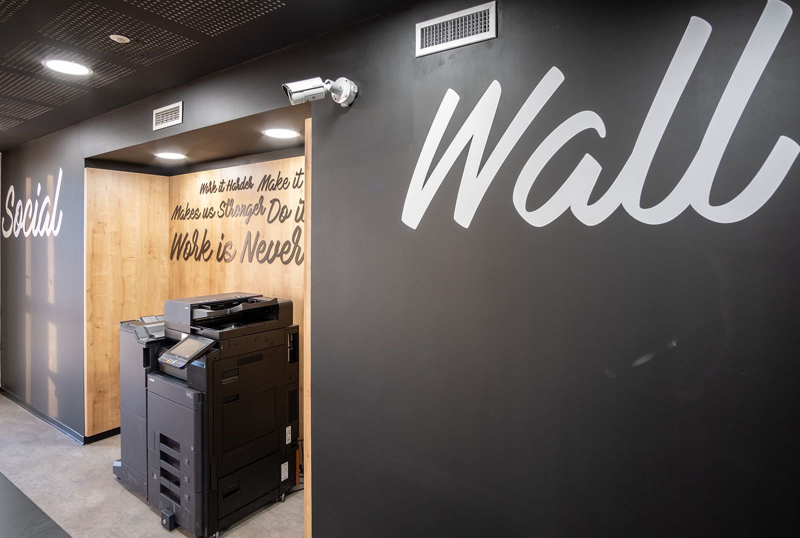A wall with motivational text and a printer.