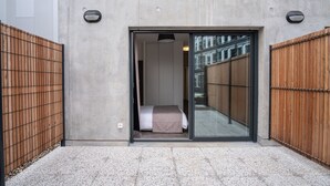 A modern building with a large sliding glass door leading to a room with a bed and a view of the street. - Student Factory Bordeaux (Bordeaux)