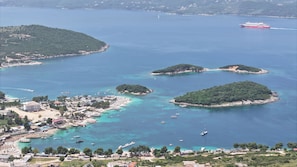 Une ville côtière entourée de nombreuses îles, avec une eau d’un bleu cristallin et un ferry visible au loin.