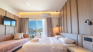 Ett modernt hotellrum med en säng, en soffa, en TV och en balkong med utsikt.
