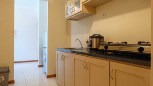 A kitchen with light wooden cabinets, a stainless steel range, and a sink. - Grand Palace Kemayoran Apartment For Lifestyle Living (Jakarta)