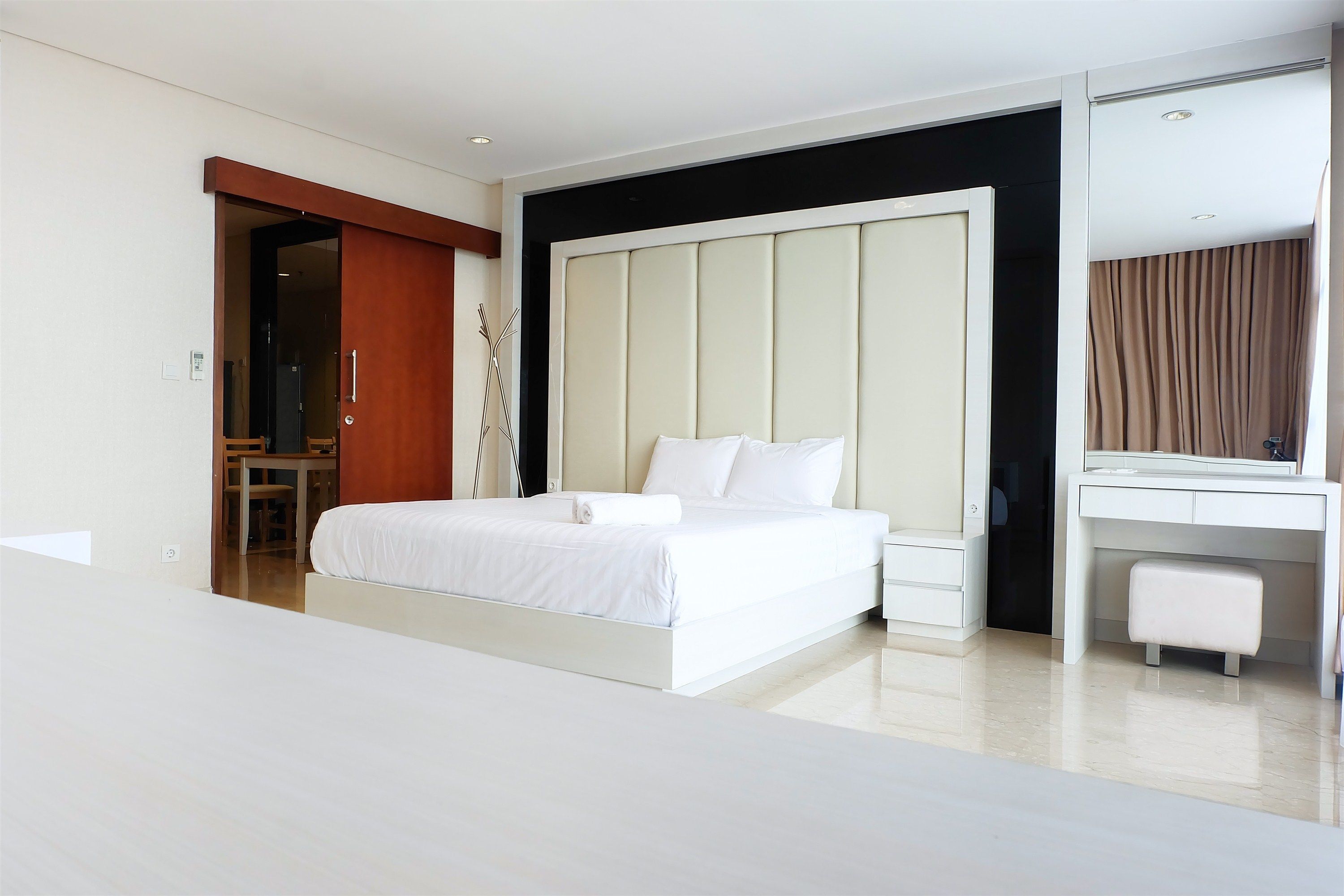 Ein modernes Hotelzimmer mit einem großen Bett, einem Schreibtisch und einem Kleiderschrank.