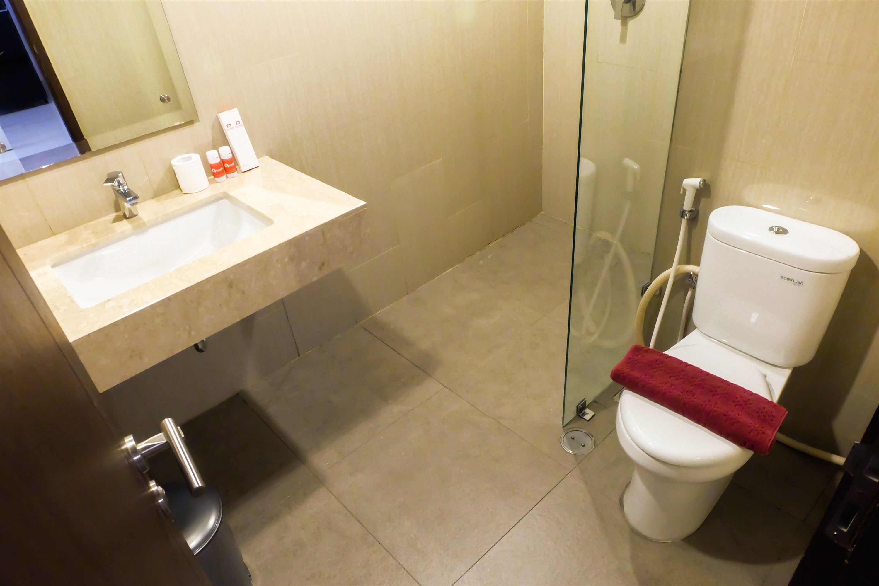 A bathroom with a sink, toilet, and glass shower enclosure.