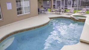 A swimming pool with a curved edge, surrounded by lounge chairs and a patio area. - Ip60375 - Rolling Hills Estates - 4 Bed 3 Baths Villa (Kissimmee)