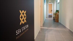 Un corridoio con un cartello che riporta la scritta 'SEA STATION POLIGNANO ROOMS'.