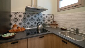 Una cucina con piano di lavoro nero, lavandino in acciaio inossidabile e finestra sopra il lavello.