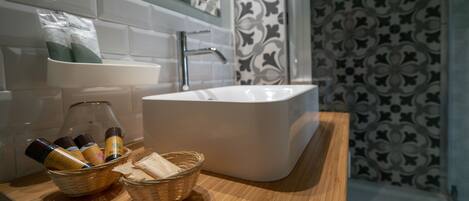 Un baño con lavamanos blanco, encimera de madera y pared con diseño.