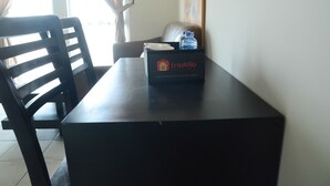 A table with a box labeled "Travelio" containing a water bottle and a plate. - Apartment Taman Semanan Cengkareng Great Value (Jakarta)