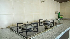 A kitchen with a gas stove and a stainless steel sink. - Apartment Taman Semanan Cengkareng Great Value (Jakarta)