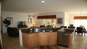 A modern kitchen with a central island, wooden cabinets, and a built-in dishwasher. - Ip60402 - Sand Hill - 5 Bed 3 Baths Villa (Davenport)