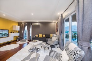 Departamento Deluxe, 2 habitaciones, acceso a la alberca, vista a la alberca | Sala de estar | Smart TV de 160 cm con canales digitales, televisión y chimenea