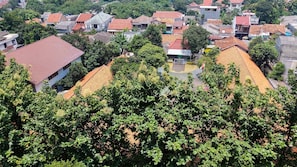 A residential area with houses featuring red-tiled roofs and lush greenery. - Good Studio 23 Kebagusan City Apartment (Jakarta)