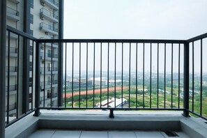 Varanda com grade de metal e vista para a cidade.