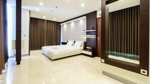 Une chambre à coucher moderne avec un grand lit, des étagères intégrées et une vitrine en verre.