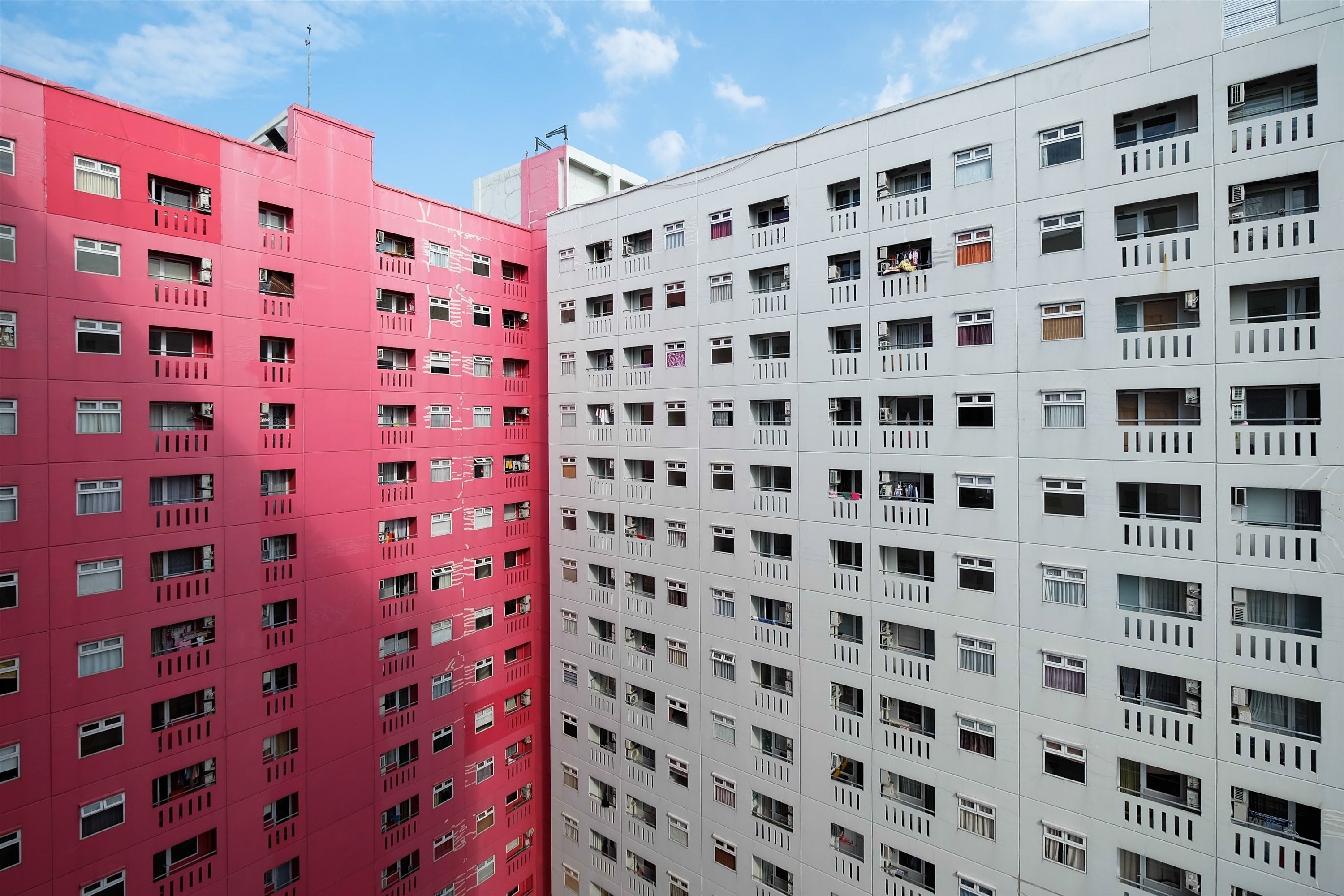 Un edificio de gran altura con múltiples pisos, cada uno con numerosas ventanas y balcones.