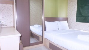 A bedroom with a bed, a dresser, and a mirror.
