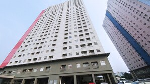 A high-rise building with multiple floors, featuring a prominent red stripe on one side.