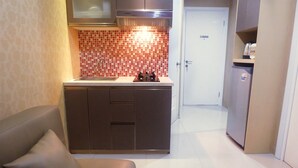 A compact kitchen with a gas stove, a microwave, and a refrigerator.