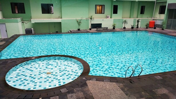 An indoor swimming pool with a tiled floor and a circular hot tub area. - Warm Cozy Menteng Square Apartment (Jakarta)