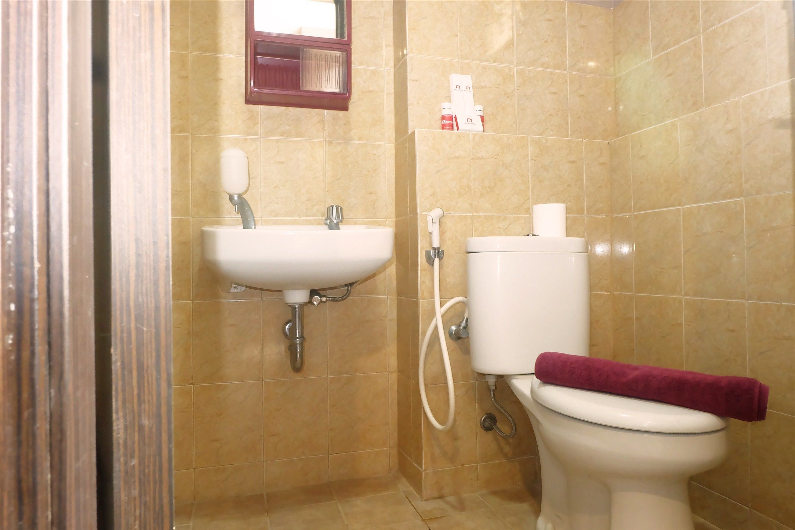 Un baño con lavamanos, inodoro y toallero.