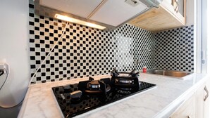 A modern kitchen with a black and white checkered backsplash, a gas stove, and a stainless steel sink.