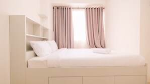 A minimalist bedroom with a bed, built-in shelving, and a window with curtains. - Minimalist Bassura Apartment Direct Access to Bassura City Mall (Jakarta)