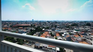 Stadtansicht, die von einem Balkon mit Geländer aus zu sehen ist.